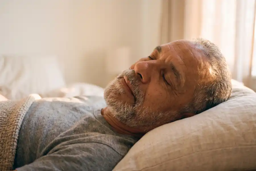 Older man resting peacefully on a couch